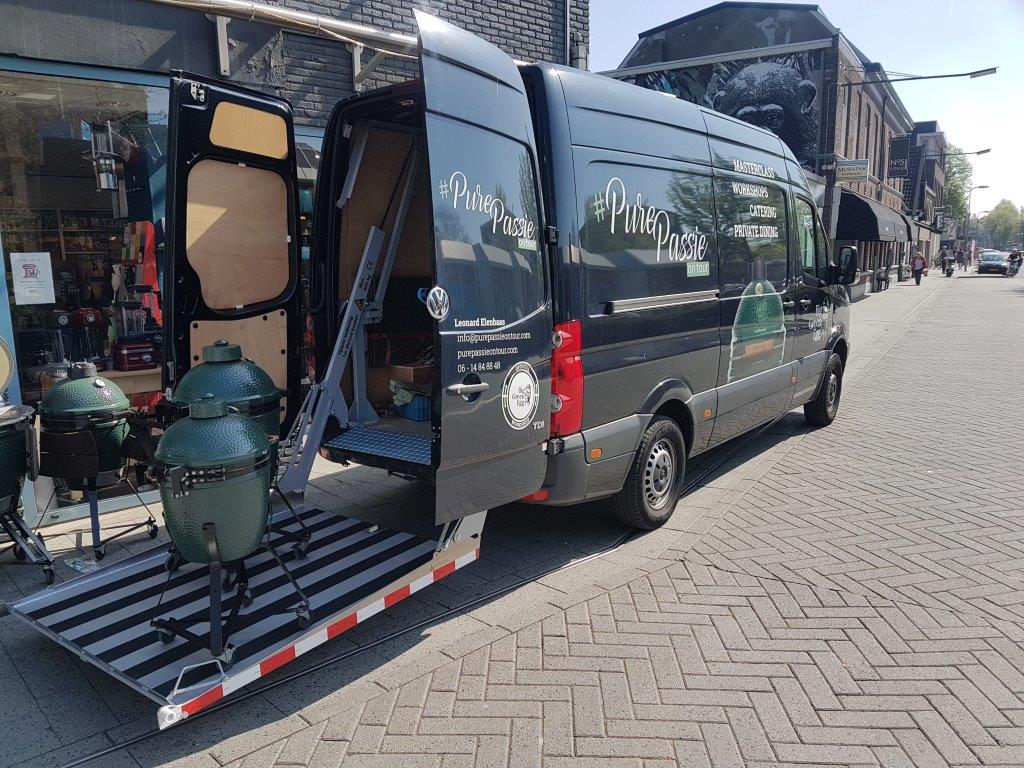Leveringsbus met kamado barbecues op straat.